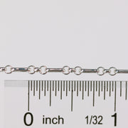Silver rolo chain with a ruler for scale on a white background