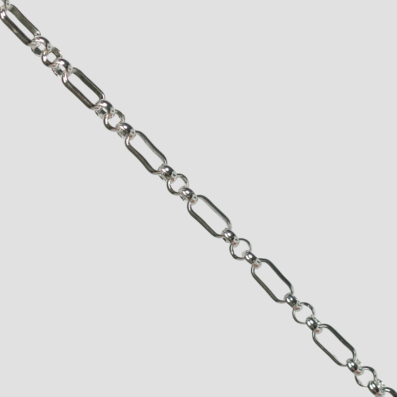 Silver rolo chain on a light gray background