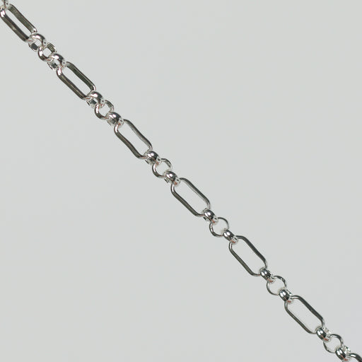 Silver rolo chain on a light gray background