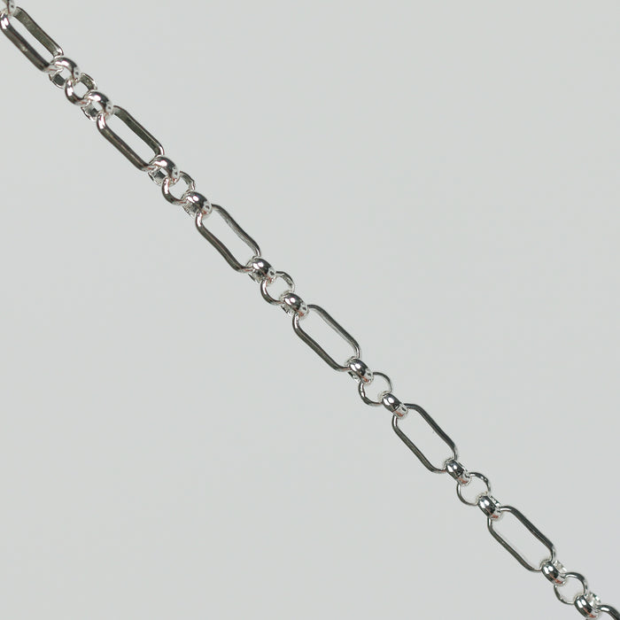 Silver rolo chain on a light gray background