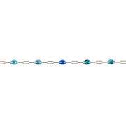 A delicate permanent jewelry chain featuring oval and elongated links, interspersed with enamel beads in shades of light blue, royal blue, and turquoise with dark inclusions, shown against a plain white background.