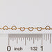 Sunstone certified heart shaped chain laying next to a ruler for measurements