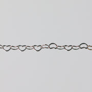 Sterling silver heart-shaped chain on a light gray background
