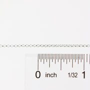 Silver chain with a ruler for scale on a white background
