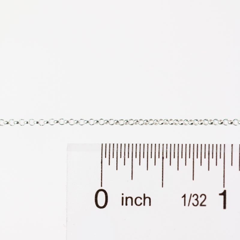 Silver chain with a ruler for scale on a white background