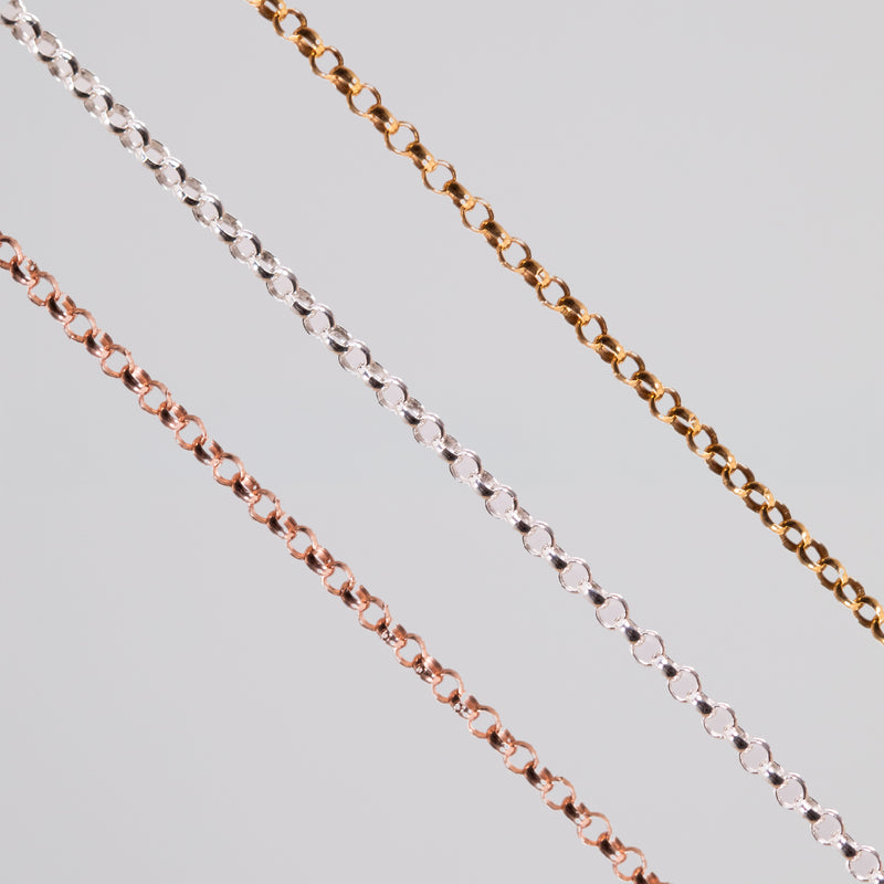 Three round linked permanent jewelry chains in different metal types and colors showcased on a light background.