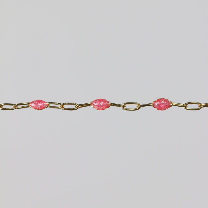Pink enamel beads are shown on a shown with a gray background