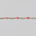 Pink enamel beads are shown on a shown with a gray background
