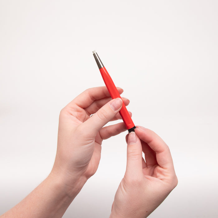 Red fiberglass brush being held by two hands diagonally in the air