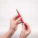Red fiberglass brush being held by two hands diagonally in the air