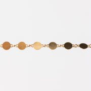 Gold bracelet with circular links on a white background