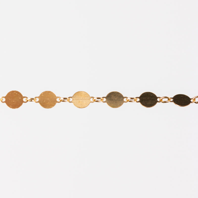 Gold bracelet with circular links on a white background
