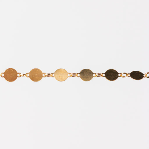 Gold bracelet with circular links on a white background
