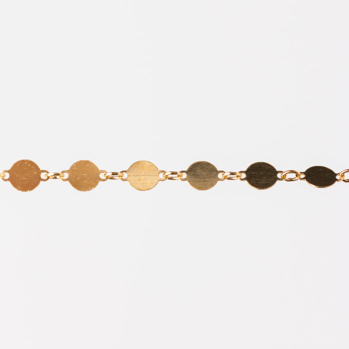 Gold bracelet with circular links on a white background