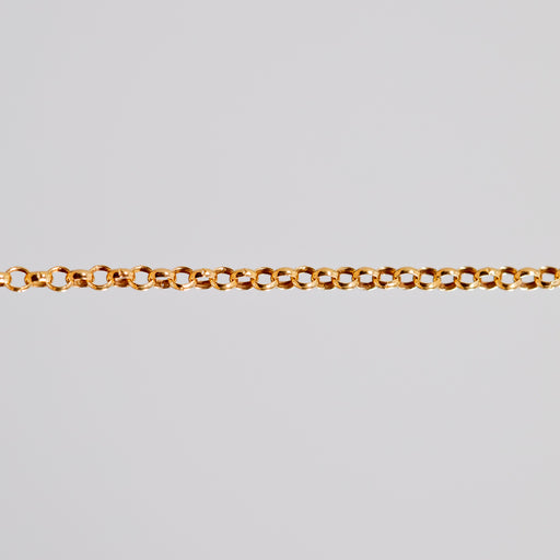 Yellow gold filled rolo chain for permanent jewelry being shown pulled tight across a light background.