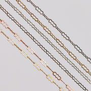 Crinkled paperclip chains stacked in a row showing different colors and metal types