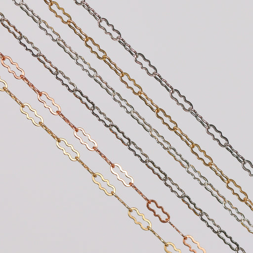 Crinkled paperclip chains stacked in a row showing different colors and metal types