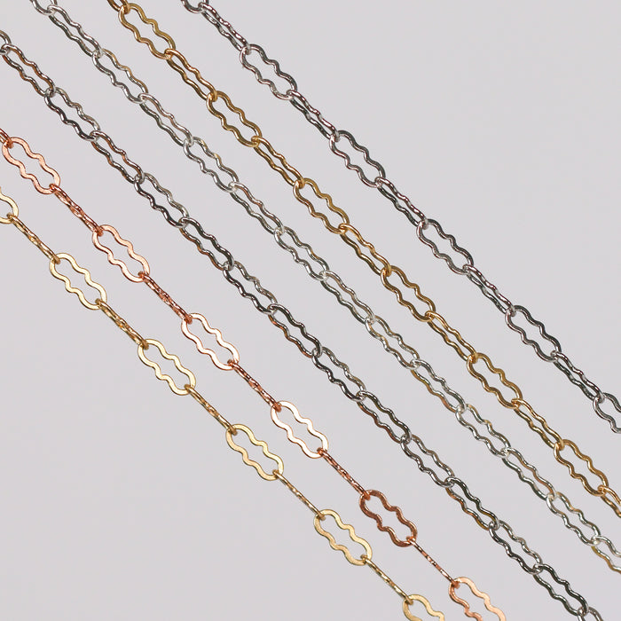 Crinkled paperclip chains stacked in a row showing different colors and metal types