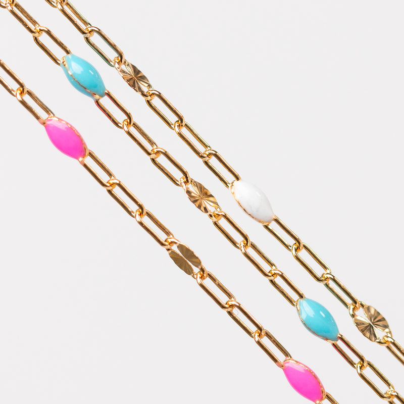 Gold chain for permanent jewelry with colorful enamel beads on a white background