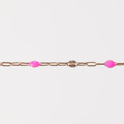 Rose gold chain bracelet with pink enamel beads on a white background