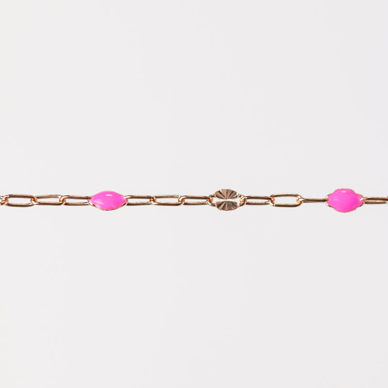 Rose gold chain bracelet with pink enamel beads on a white background