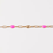 Yellow gold bracelet with pink enamel beads on a white background
