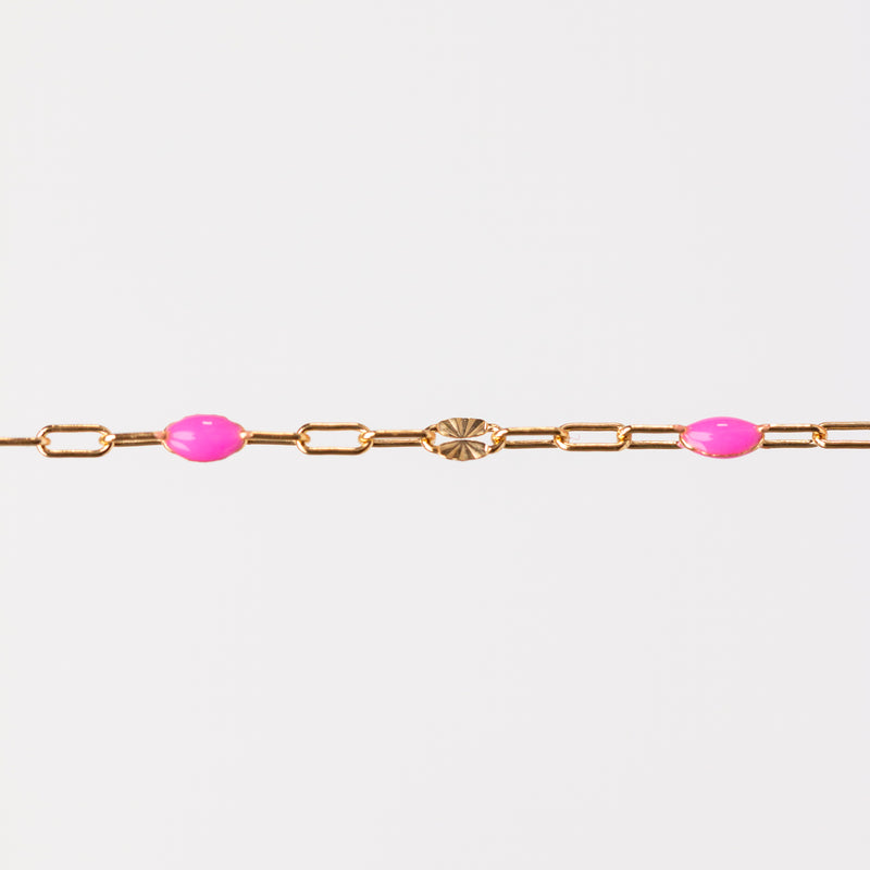 Yellow gold bracelet with pink enamel beads on a white background