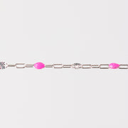 Silver bracelet with pink enamel beads and starburst links on a white background