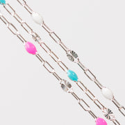 Silver chain for permanent jewelry with colorful enamel beads on a white background