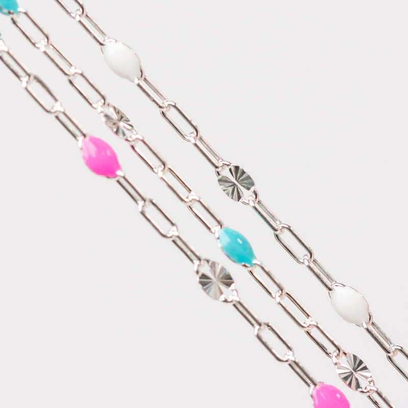 Silver chain for permanent jewelry with colorful enamel beads on a white background