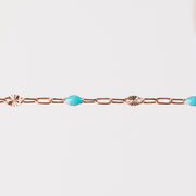 Rose gold chain bracelet with turquoise beads made from enamel on a white background