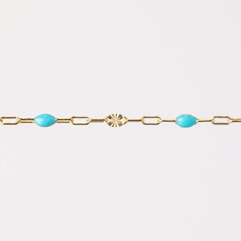 Gold bracelet with turquoise beads made from enamel on a white background