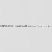 Silver chain on a light gray background with white enamel on it