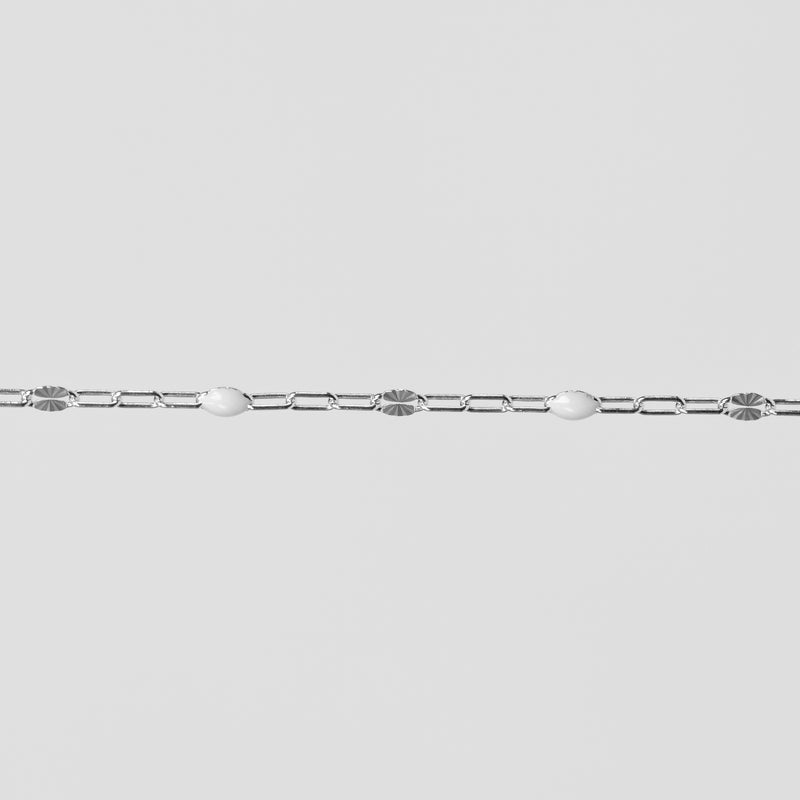 Silver chain on a light gray background with white enamel on it