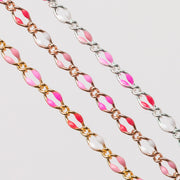 Zoomed in photo of three chains in gold , rose gold, silver. Each have alternating enamel beading in soft pink, hot pink, pinky red, and white.