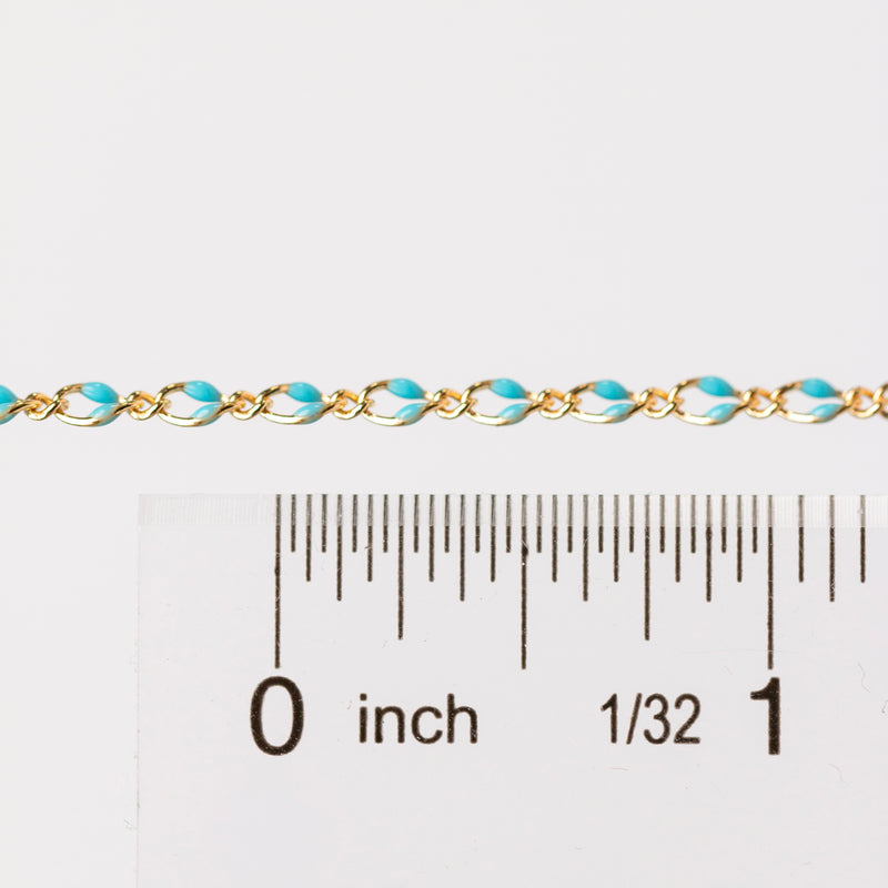 Chain is being held next to a ruler with inches as the measurement. The chain is gold filled yellow with blue enamel beading.