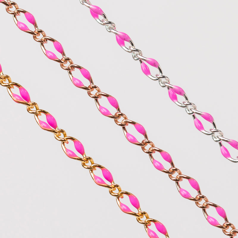 Three chains depicted with pink enamel. One is gold, one is rose, one is silver. Shown up close on a simple gray background.