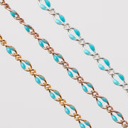 Three chains depicted all with blue enamel. One chain is yellow gold filled, one is rose gold filled, and the last is silver.