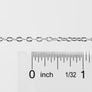 Silver textured oval links up against a ruler to help with meaurements and length.