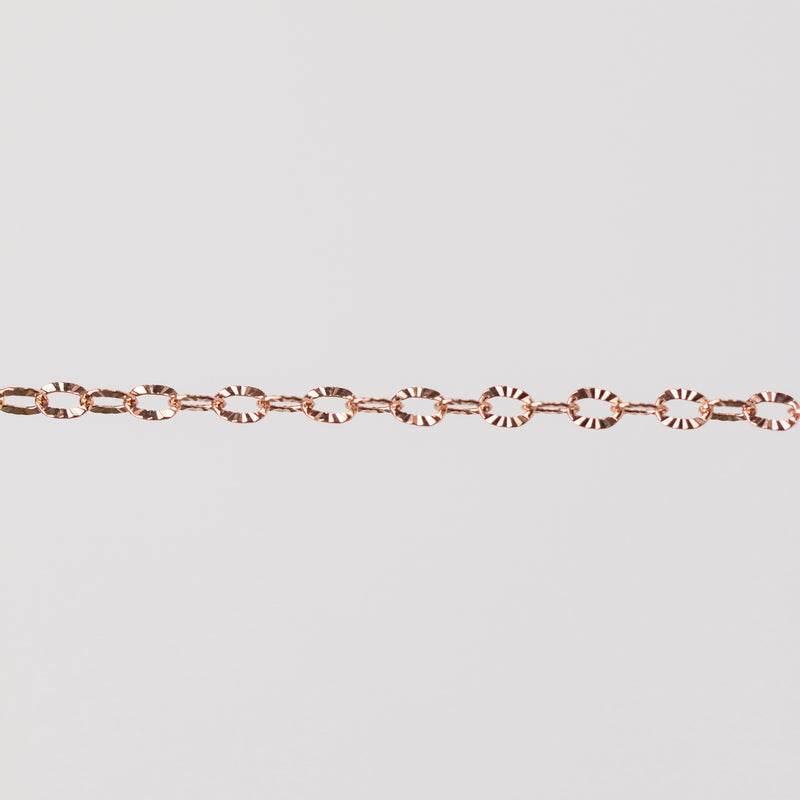Rose gold filled oval links with hammered texture. Zoomed in on chain with gray background.