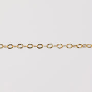 Shiny textured oval links reflecting yellow gold. Hammered starburst pattern.