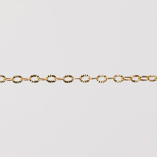 Shiny textured oval links reflecting yellow gold. Hammered starburst pattern.