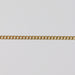 Gold curb chain laying flat on a gray background
