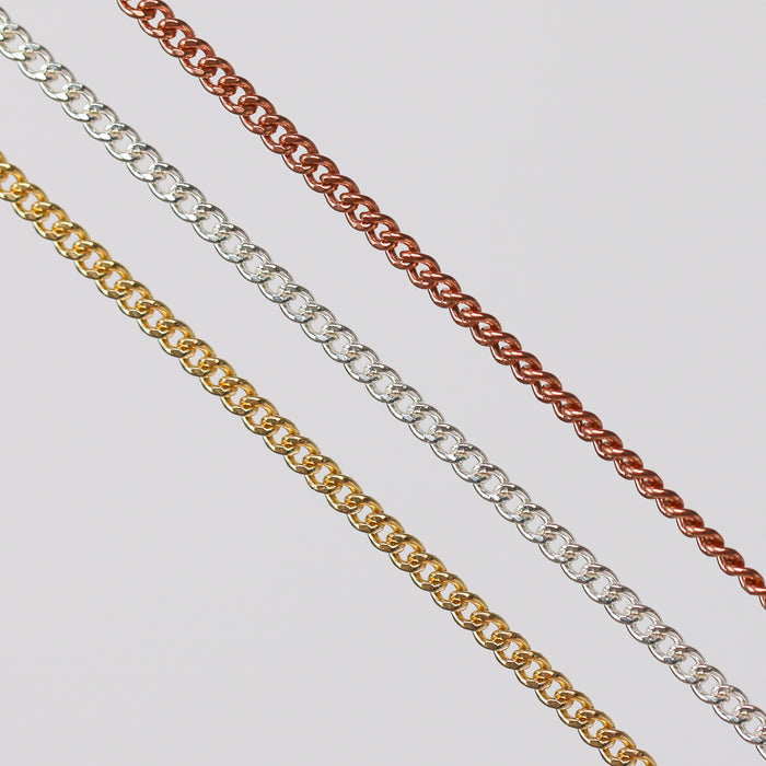 Three pj chains laying side by side in different metal types over a gray background