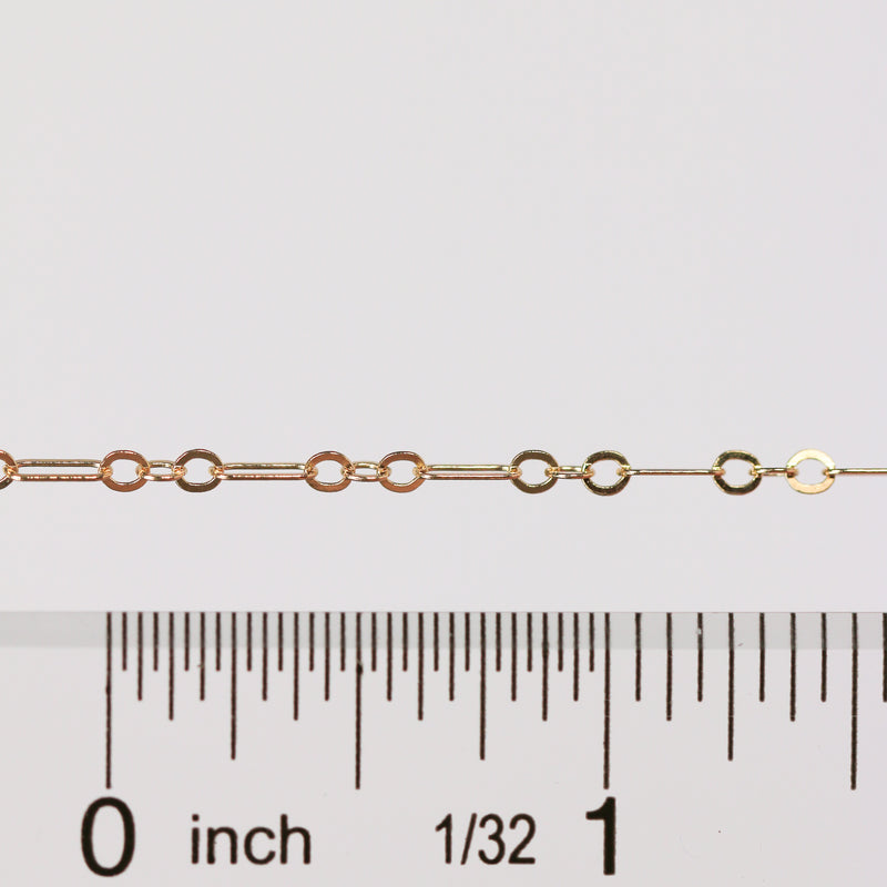 Gold chain with a ruler for scale on a white background