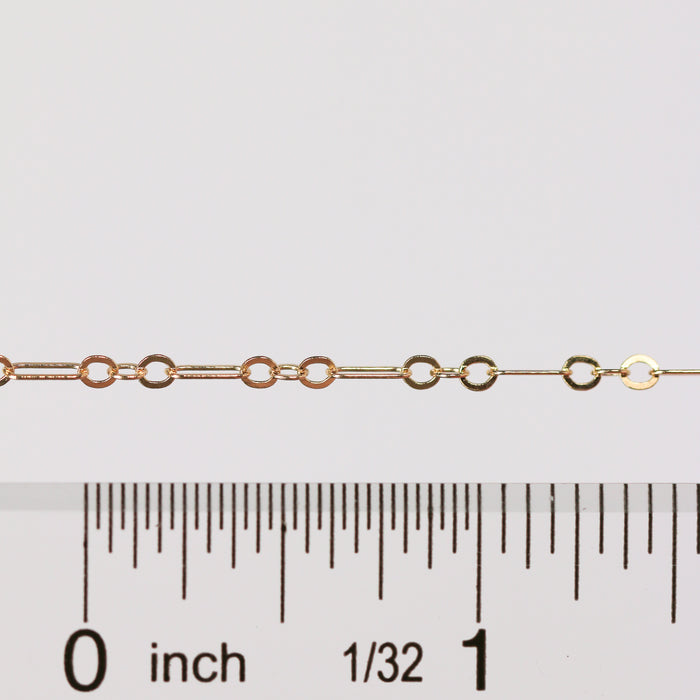 Gold chain with a ruler for scale on a white background