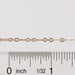 Gold chain with a ruler for scale on a white background