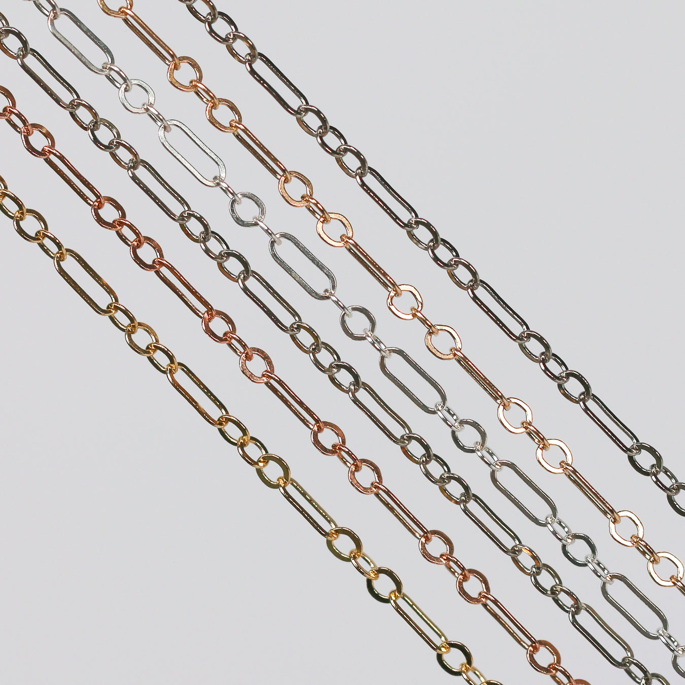 Set of metal cable paperclip chains in various colors on a light gray background