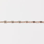 Rose gold chain bracelet on a light gray background