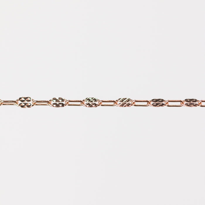 Rose gold chain bracelet on a light gray background
